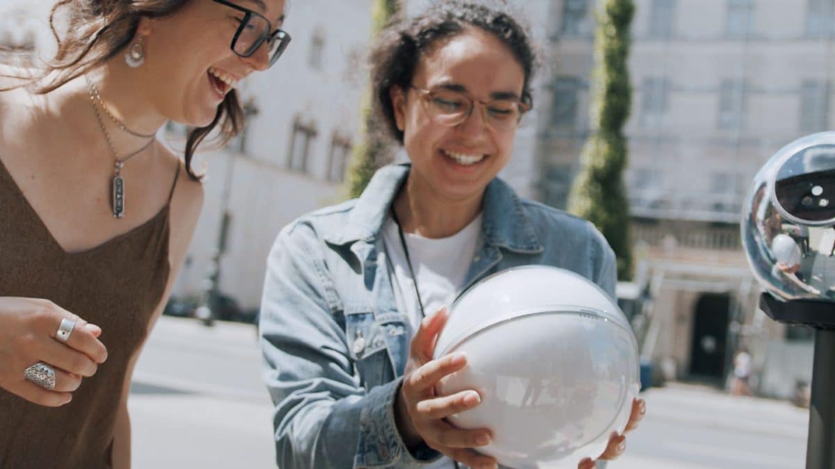 Jovens mulheres segurando Orb da World e sorrindo