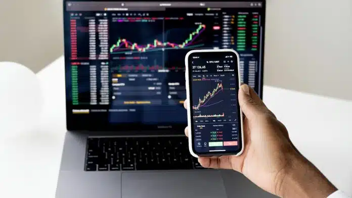 Tela de celular e notebook em homebroker da Binance no par bitcoin e usdt criptomoedas moedas