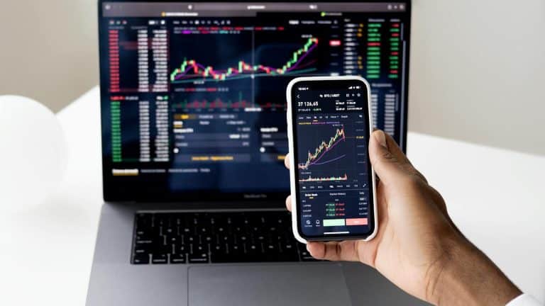 Tela de celular e notebook em homebroker da Binance no par bitcoin e usdt criptomoedas moedas