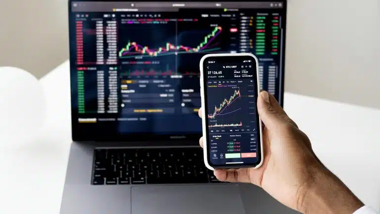 Tela de celular e notebook em homebroker da Binance no par bitcoin e usdt criptomoedas moedas