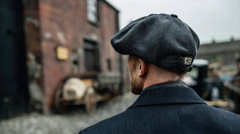 Homem usando boina inglesa, comum na série Peaky Blinders. Fonte: Midjourney.
