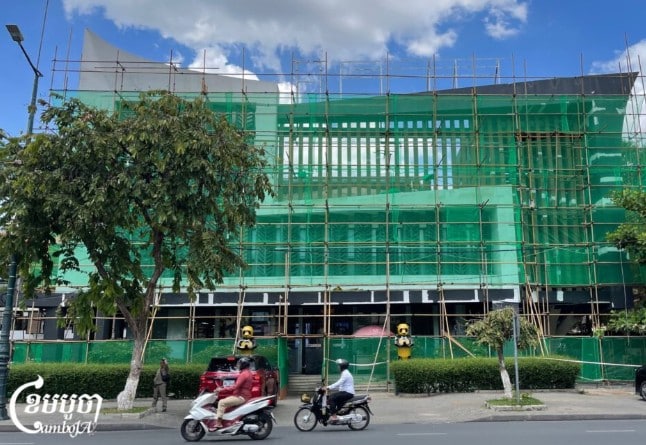 Andaimes são vistos do lado de fora do escritório da Huione Pay após a remoção da placa em Phnom Penh, Camboja, em 7 de maio de 2025. (CamboJA/Pring Samrang)
