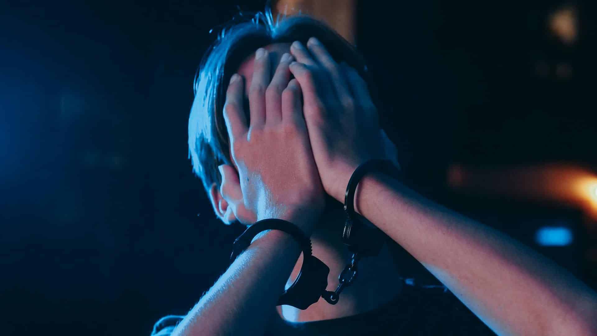 Homem preso com mãos no rosto