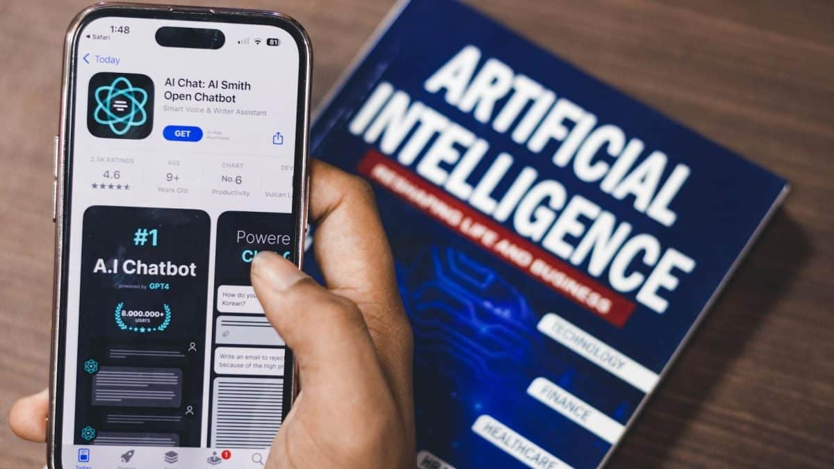 Pessoa utilizando aplicativo de inteligência artificial próximo a livro sobre o tema