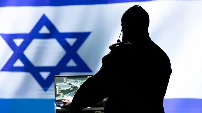 Homem com computador ligado em frente a bandeira de Israel criptomoedas Irã