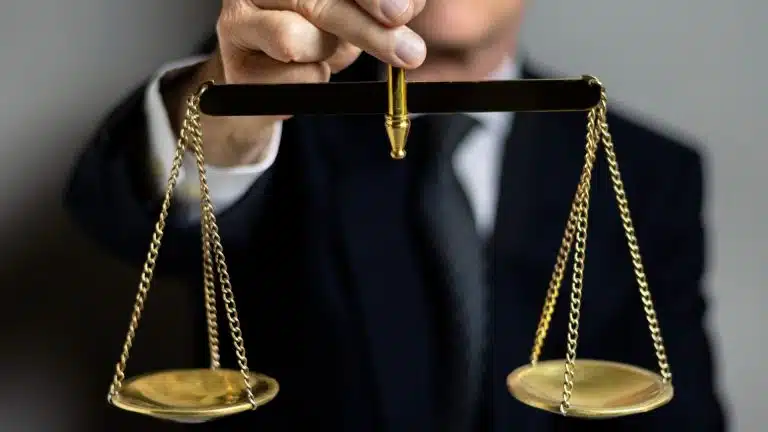 Homem segurando balança da justiça criptomoedas empresa