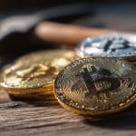 Moedas de Bitcoin e picareta, simbolizando mineração.