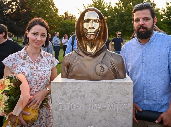Criadores da estátua de Satoshi Nakamoto na Hungria posam ao lado