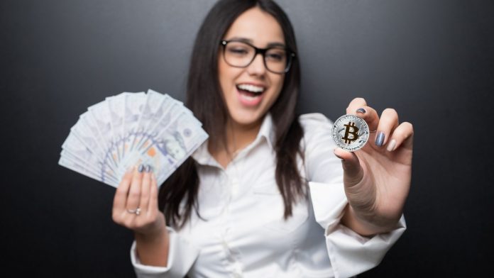 Mulher segurando notas de Dólar e bitcoin