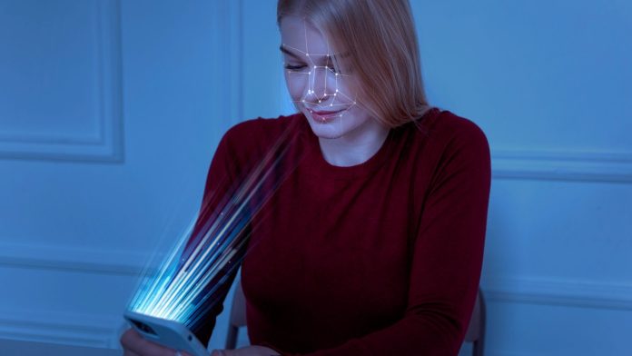 Mulher tendo face escaneada por smartphone blockchain Sentinela Digital