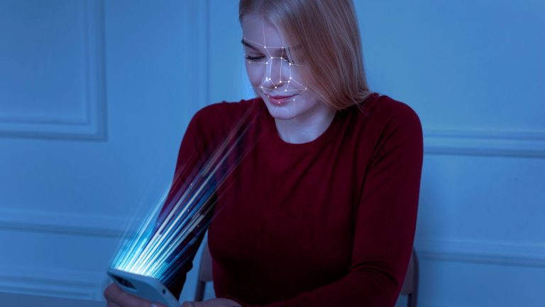 Mulher tendo face escaneada por smartphone blockchain Sentinela Digital