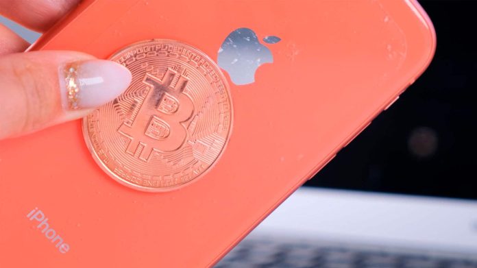 iPhone e moeda de Bitcoin.