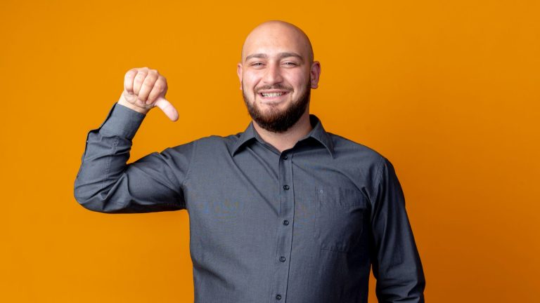 Homem apontando para baixo com dedo e fundo laranja prata bitcoin