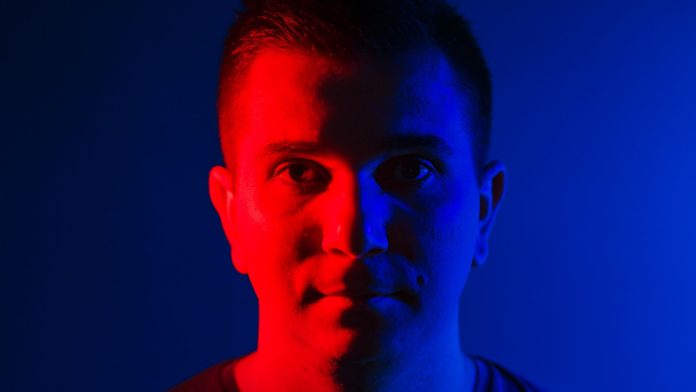 Homem com iluminação dupla vermelha e azul influencer de criptomoedas