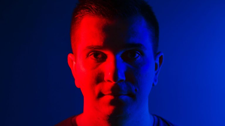 Homem com iluminação dupla vermelha e azul influencer de criptomoedas