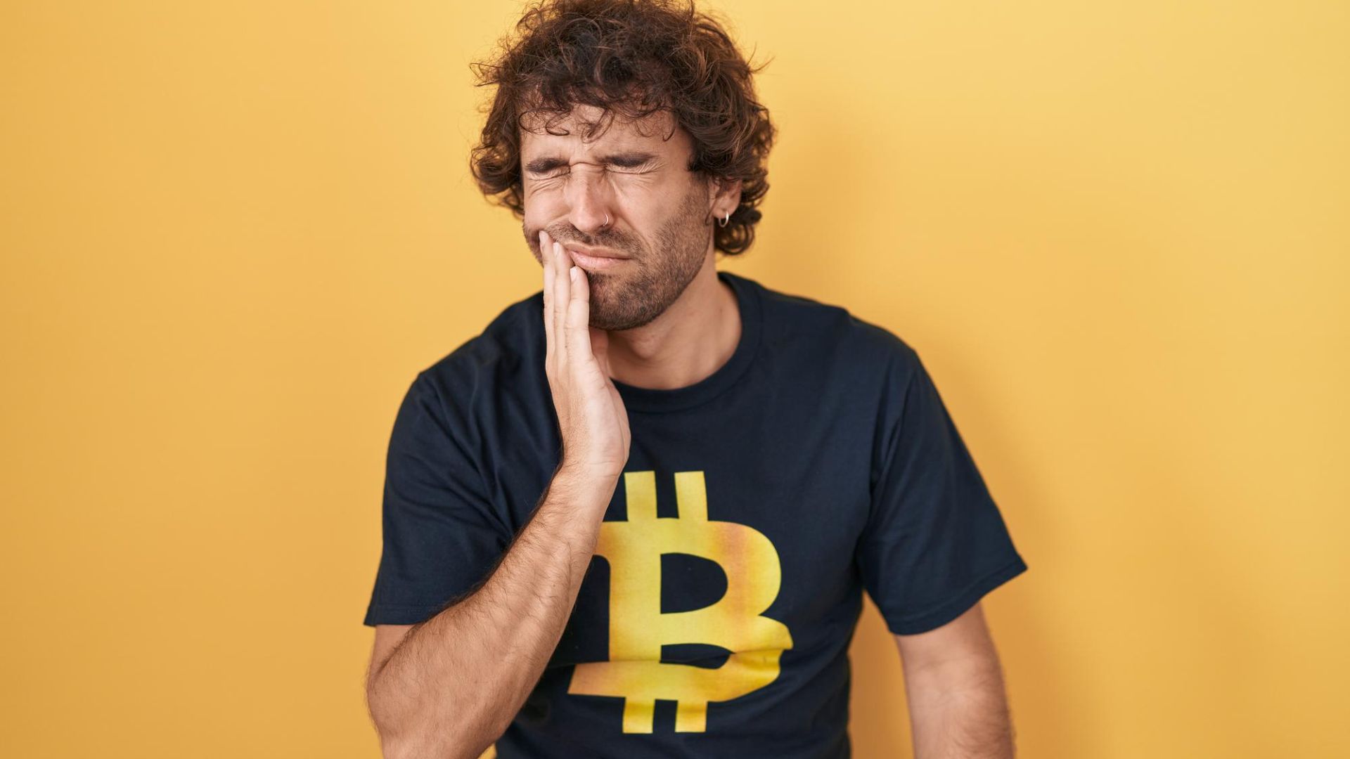 Homem preocupado com camisa mostrando símbolo do bitcoin projeto de lei P2P de criptomoedas fim taxas corretoras