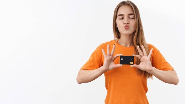 Mulher com camisa laranja segurando cartão Foxbit