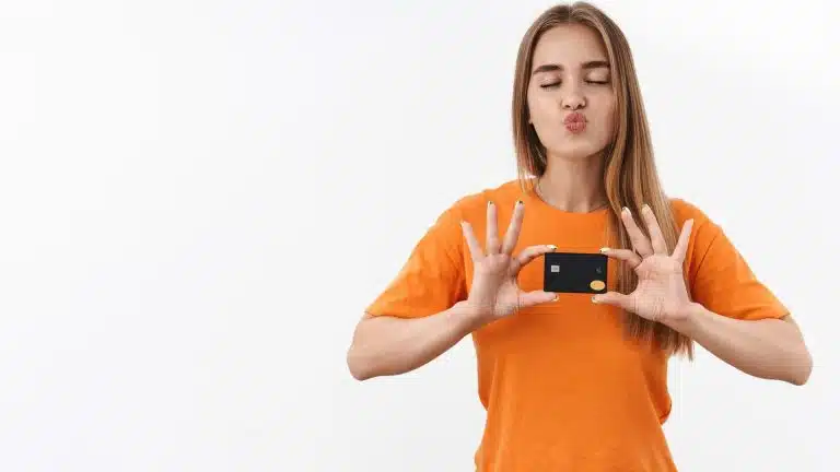 Mulher com camisa laranja segurando cartão Foxbit