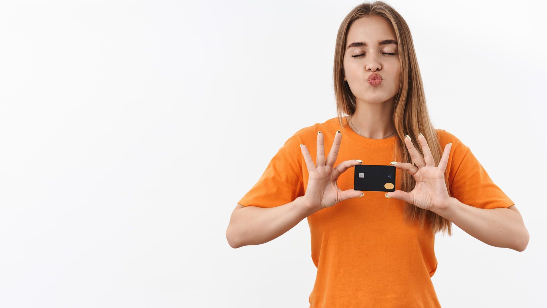 Mulher com camisa laranja segurando cartão Foxbit