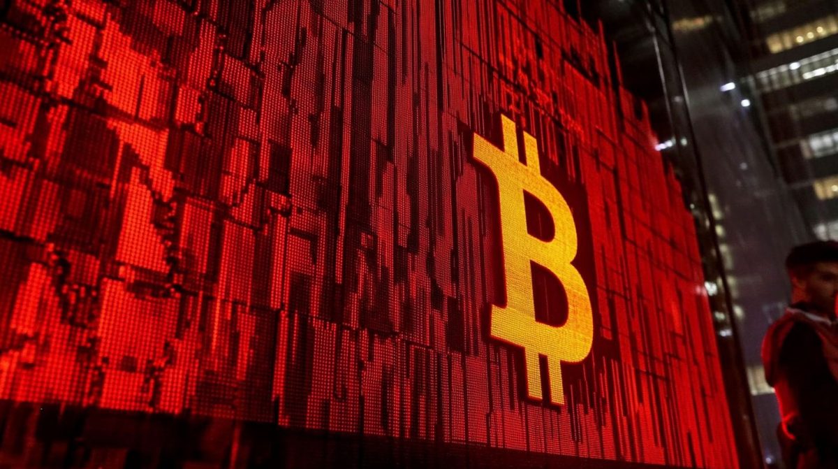 Símbolo do Bitcoin em parede vermelha.