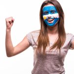 Mulher com bandeira da Argentina em destaque e expressão de felicidade e comemoração bitcoin mineração