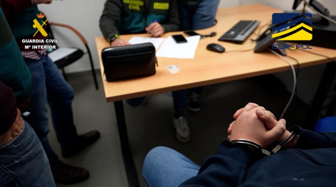 Suspeito de operar pirâmide de R$ 1,6 bilhão (€ 260 milhões) algemado em delegacia na Espanha. Fonte: Guarda Civil/Reprodução.
