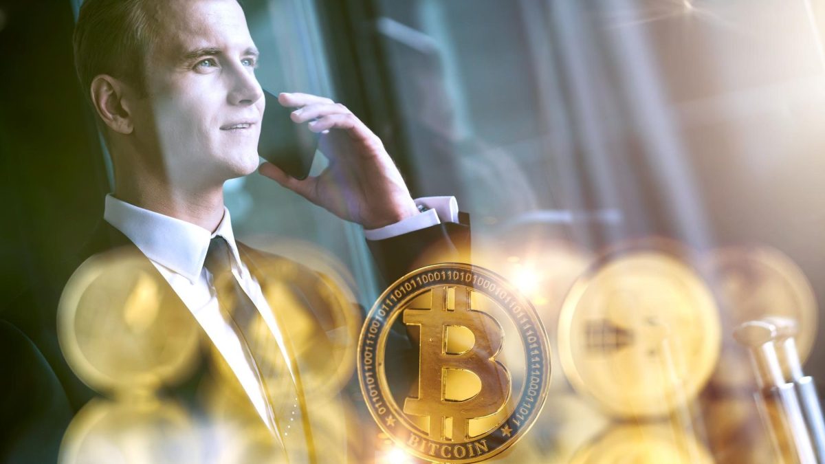 Homem de negócios ao telefone com bitcoins próximos
