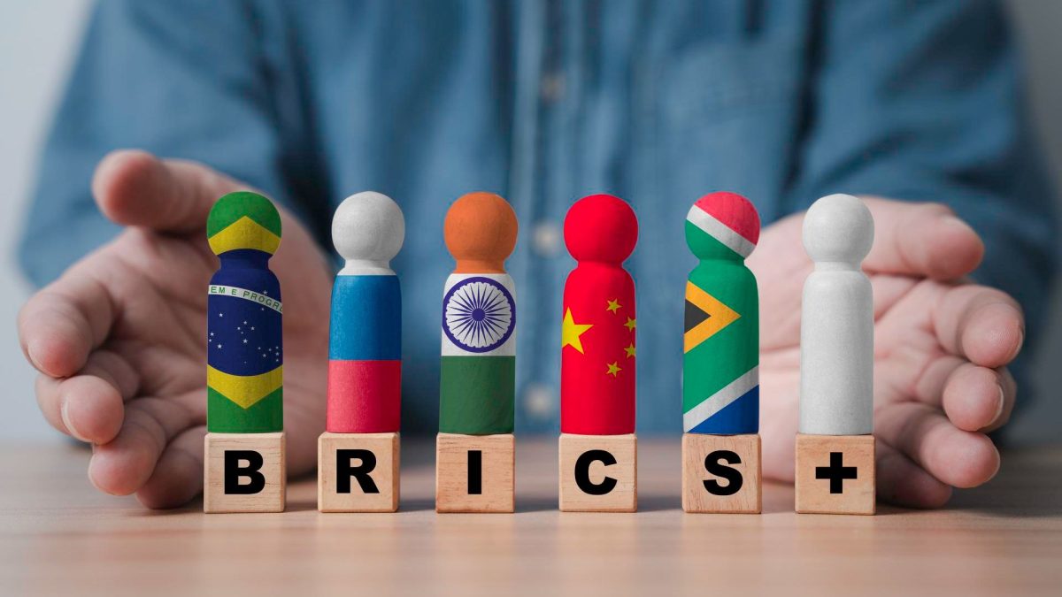 Mão com símbolo de bandeiras do BRICS moedas