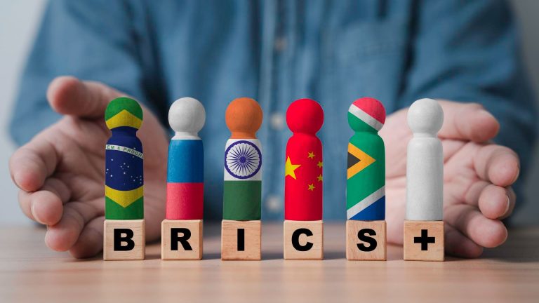 Mão com símbolo de bandeiras do BRICS moedas