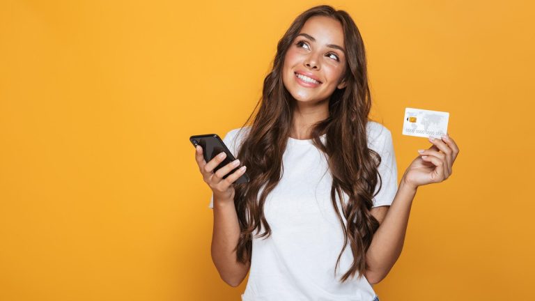 Mulher feliz segurando cartão e celular olhando para cima Visa blockchain Circle USDC Solana stablecoins EUA