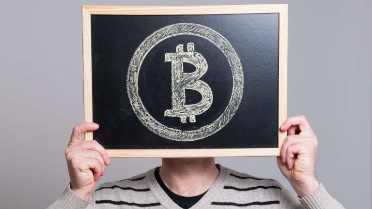 Quadro negro na mão de pessoa com símbolo do bitcoin desenhado curso técnico experimental