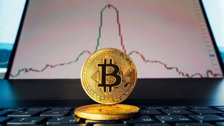 Bitcoin com gráfico de queda ao fundo