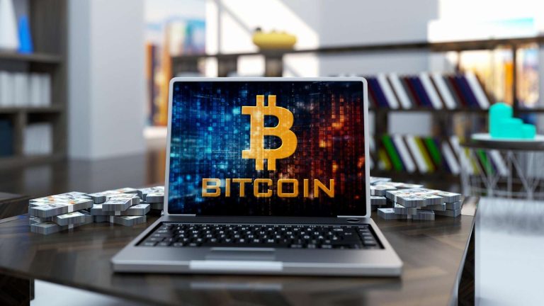 Computador com bitcoin em destaque boato bloqueio bancário