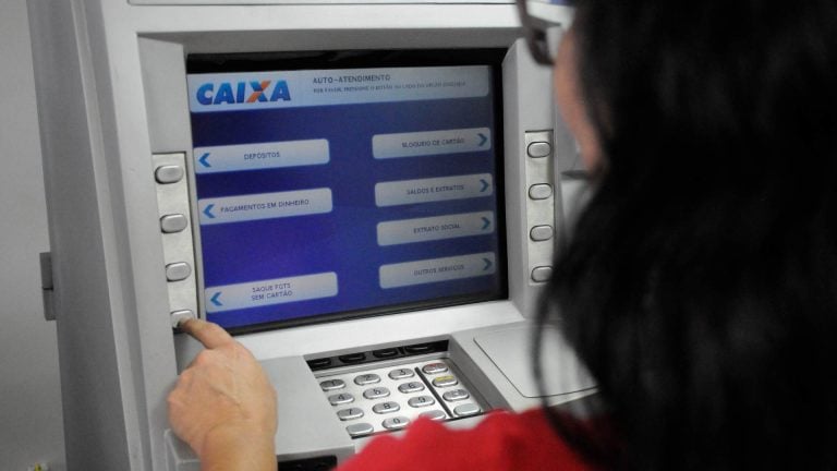 Mulher em caixa eletrônico da Caixa Econômica Federal