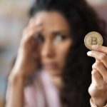 Mulher preocupada com bitcoin na mão corretora criptomoedas