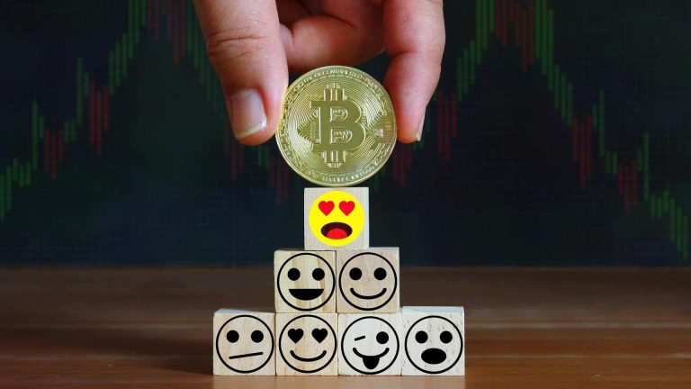 Bitcoin sobre emojis com gráfico ao fundo