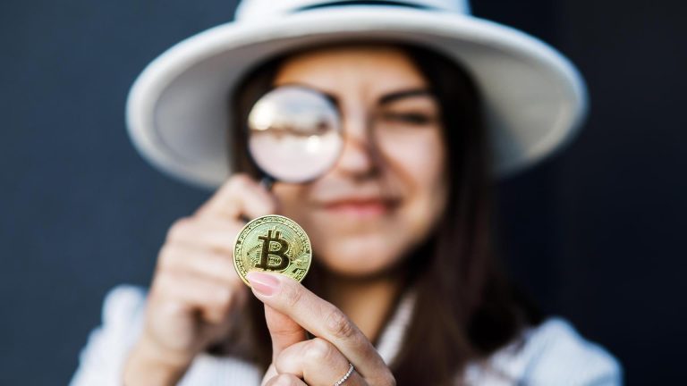 Mulher com chapéu branco segurando lupa ao observar bitcoin rastreio e apreensão de bitcoin no RN