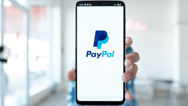 Aplicativo da PayPal na mão de uma pessoa PayPal expande stablecoin América