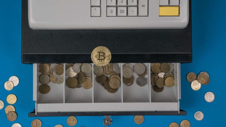 Caixa registradora aberta com bitcoin próximo contas bancárias roubadas e criptomoedas