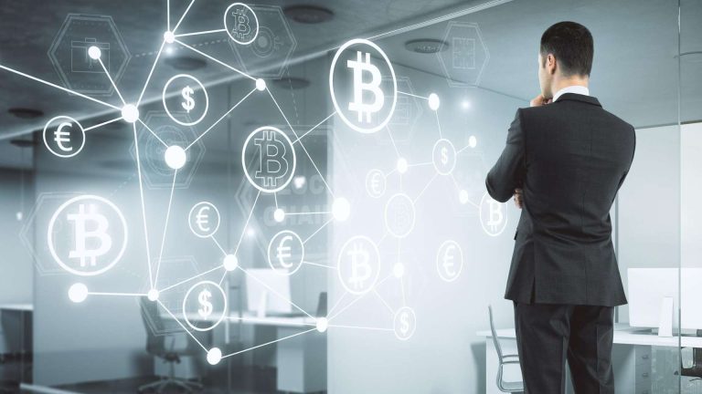Homem em pé analisando bitcoin e criptomoedas ABToken e CertiK lançam guia estratégico de segurança e conformidade regulatória para o mercado de PSAVs