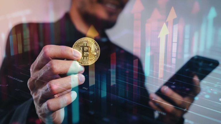 Homem segurando bitcoin com gráficos Bitcoin cai, mas interesse sobe: número de investidores no ativo cresce 50% no primeiro trimestre, aponta MB