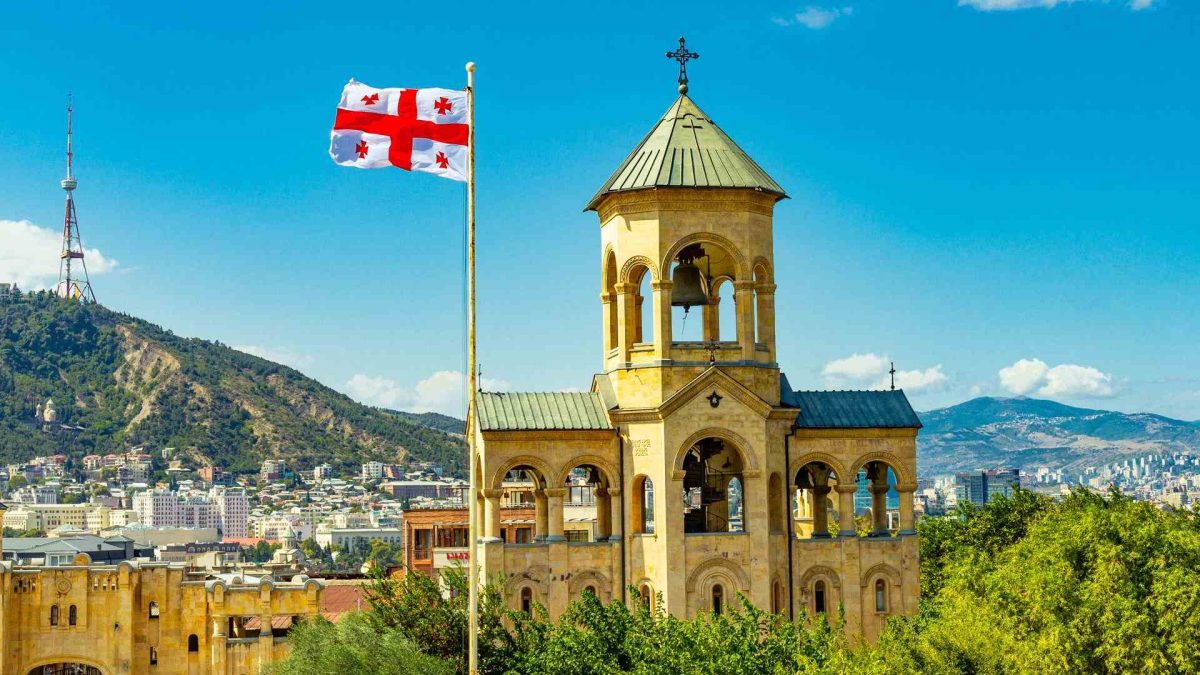 Georgia com bandeira em destaque na cidade Governo da Geórgia e Tether criam stablecoin pareada ao lari