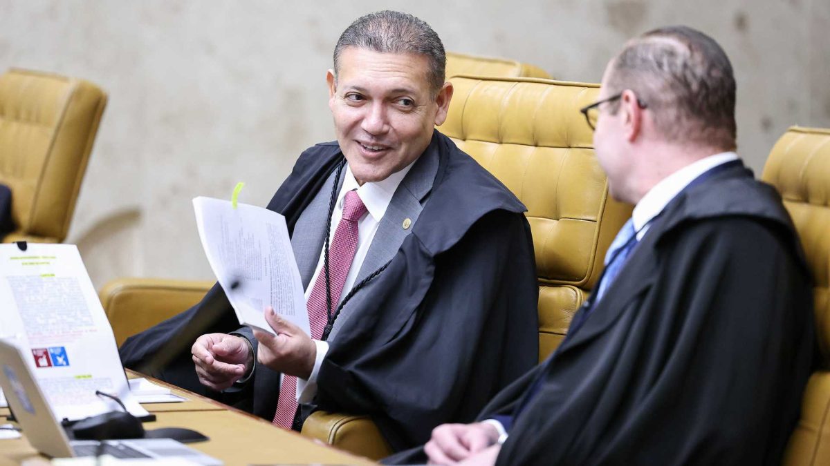 Ministro Nunes Marques segurando papel em sessão do STF