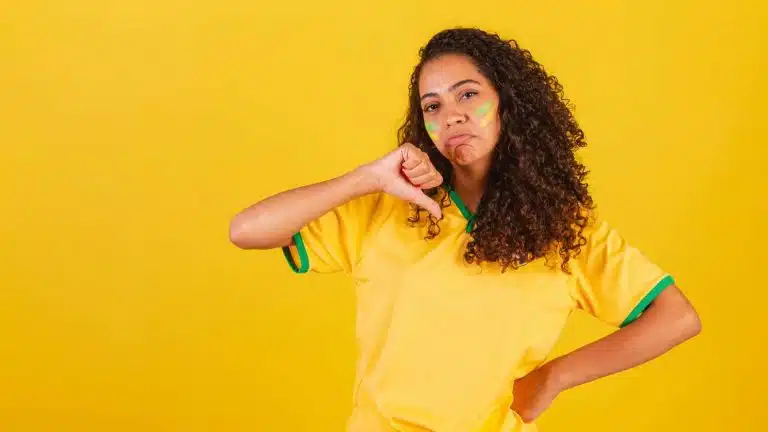 Mulher com camisa do Brasil apontando sinal de negativo