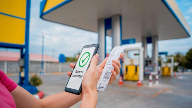 Pessoa pagando em posto de combustível com aplicativo em celular Moradores de El Salvador podem ganhar opção para pagar combustível com USDT