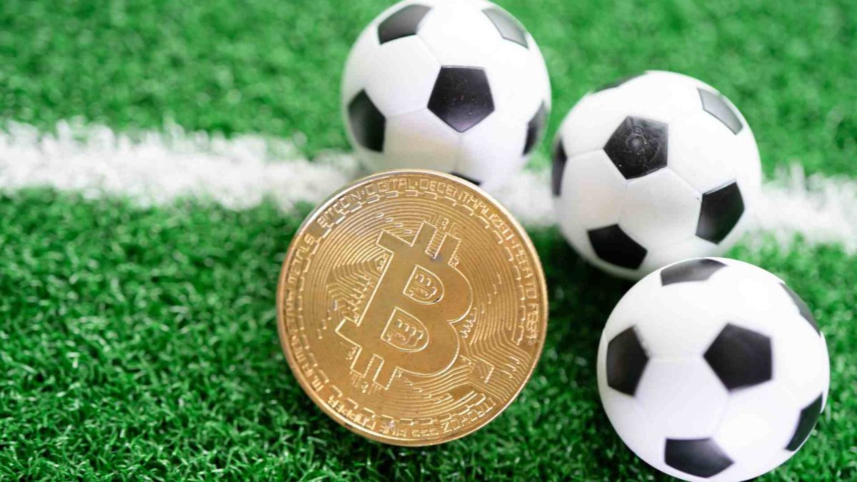 Bolas de futebol próximas de bitcoin em campo OranjeBTC reforça caixa institucional com compra milionária de bitcoin após Brasil e Haiti pela Copa do Mundo 2026