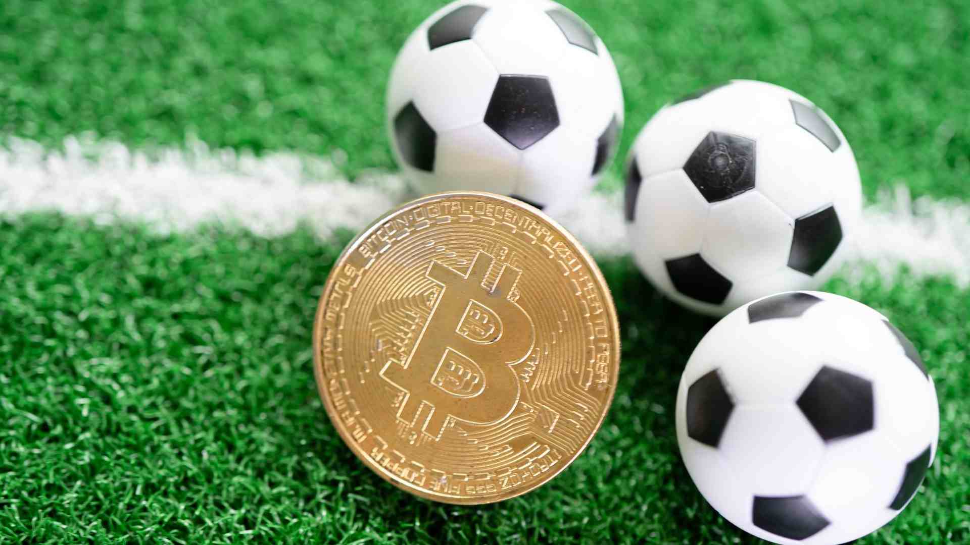 Bolas de futebol próximas de bitcoin em campo OranjeBTC reforça caixa institucional com compra milionária de bitcoin após Brasil e Haiti pela Copa do Mundo 2026