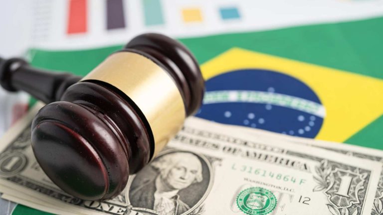Martelo da justiça com bandeira do Brasil e nota de Dólar