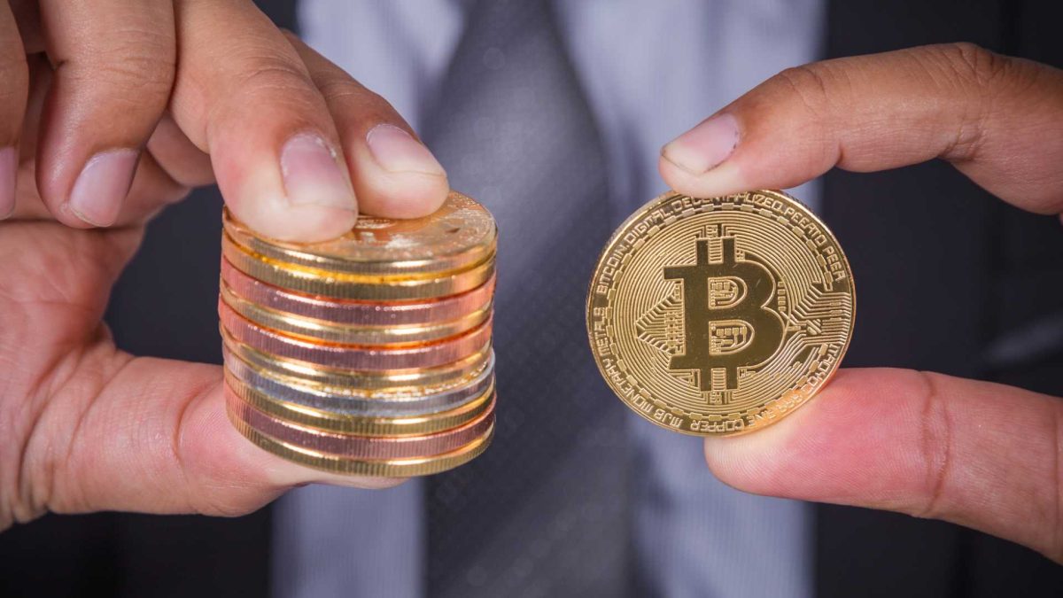 Pessoa segurando moeda com bitcoin