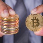 Pessoa segurando moeda com bitcoin
